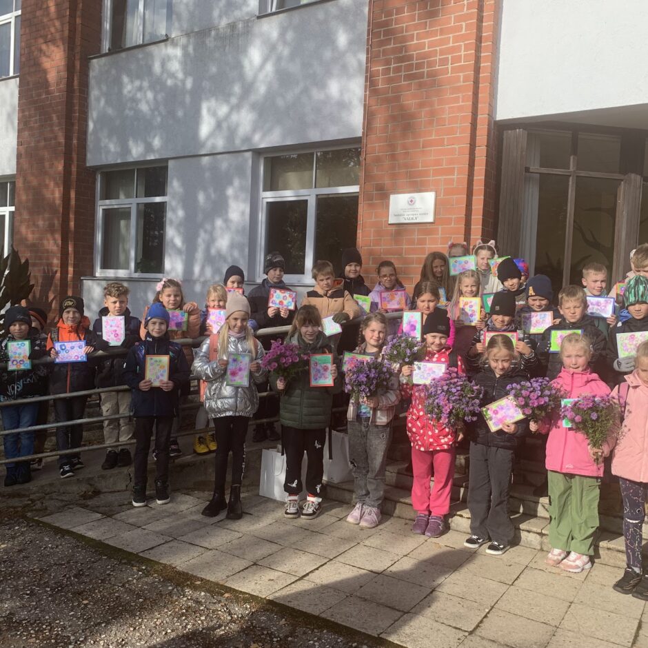 Skolēnu kopbilde pie Valkas Sociālās aprupes centra ēkas.
