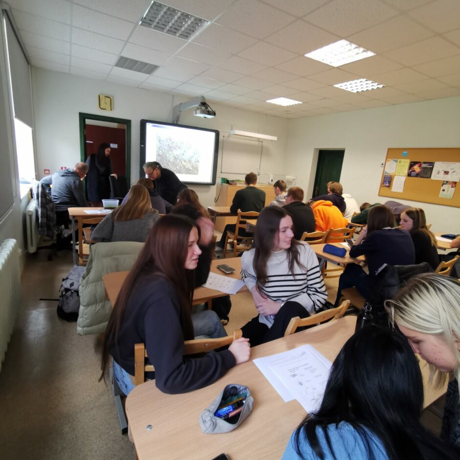 Skolēni darbojas un sadarbojas, veicot uzdevumus klasē.