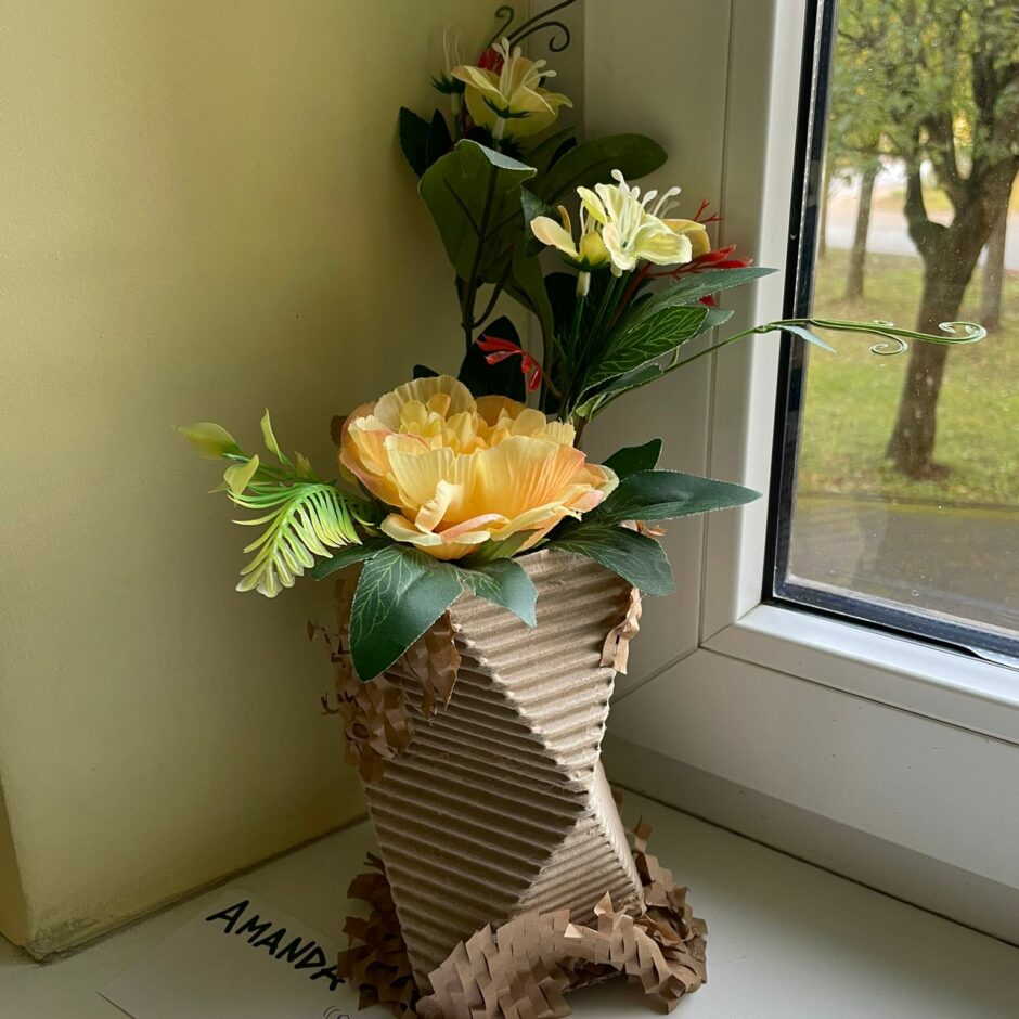 Skolēna veidots ikebanu puķu pods no kartona iepakojuma.